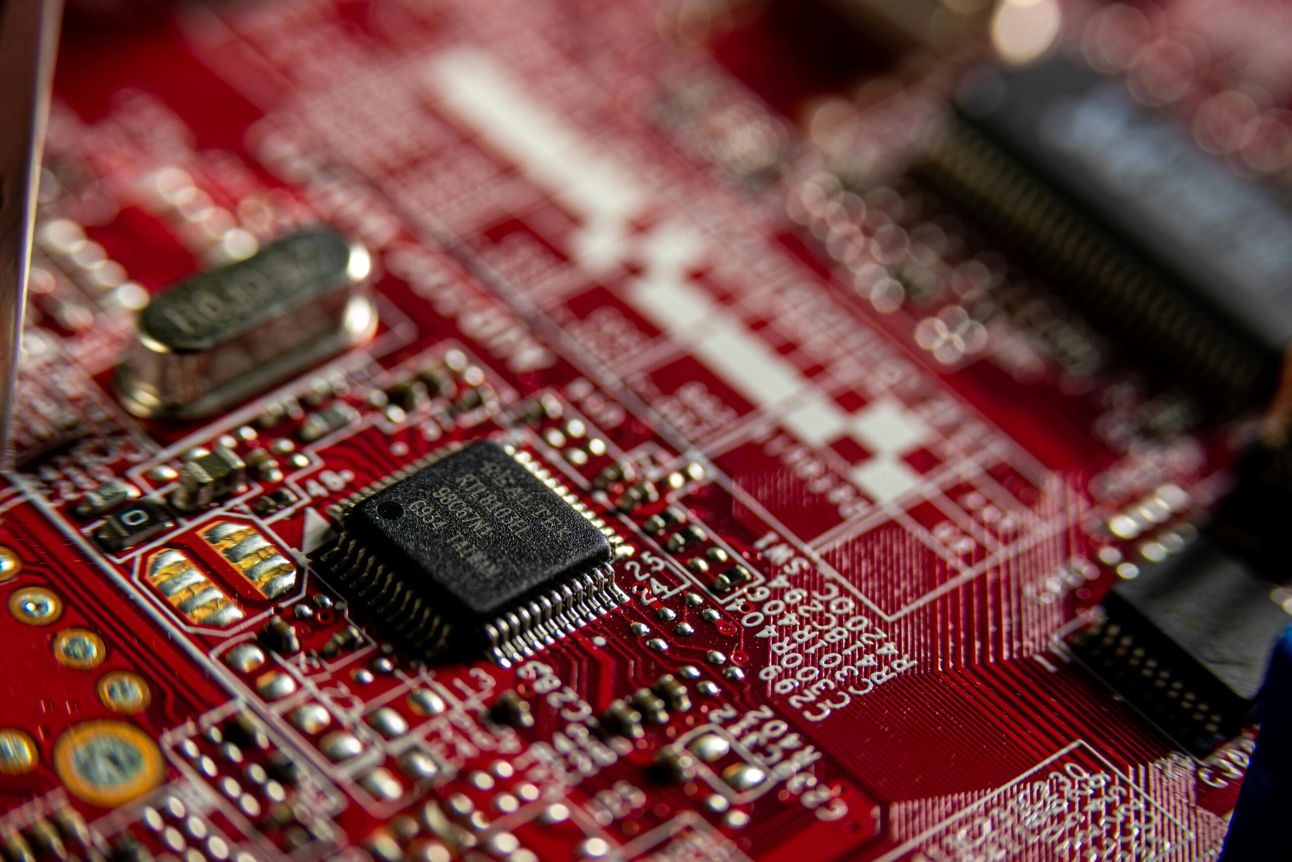 Sobre el universo Kite Wars Detailed macro shot of a red circuit board, highlighting electronic components and microchips.